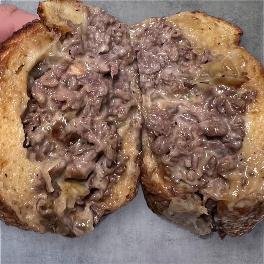 Cheesesteak at Alessio Seafood Grille, cut open to show meat, melted cheese, and onions