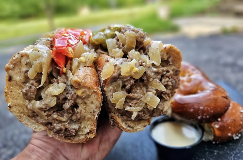 Gazzo’s cheesesteak with onions, long hots, cheese and garlic butter, cut in half